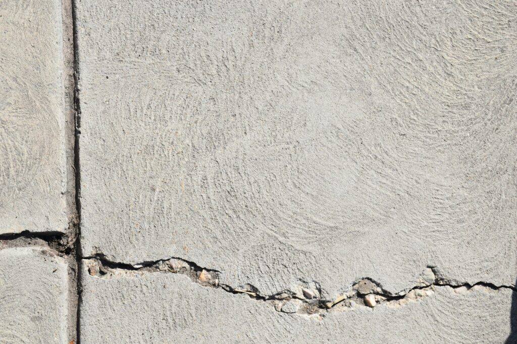 Close-up view of a cracked concrete surface with distinct textures in Logan, Utah.